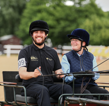 Participant and volunteering in carriage smiling happily.
