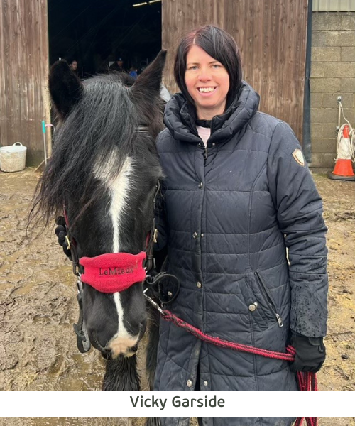 Vicky Garside stands next to a pony, holding its reins.