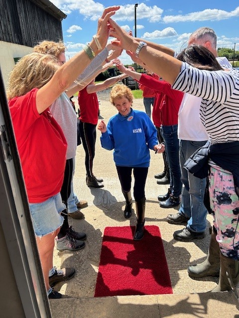 Carol entering the porta cabin on Monday under a “Guard of Honour” of volunteers when Colchester RDA celebrated her award.