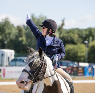 A dressage rider salutes to mark the end of their test.