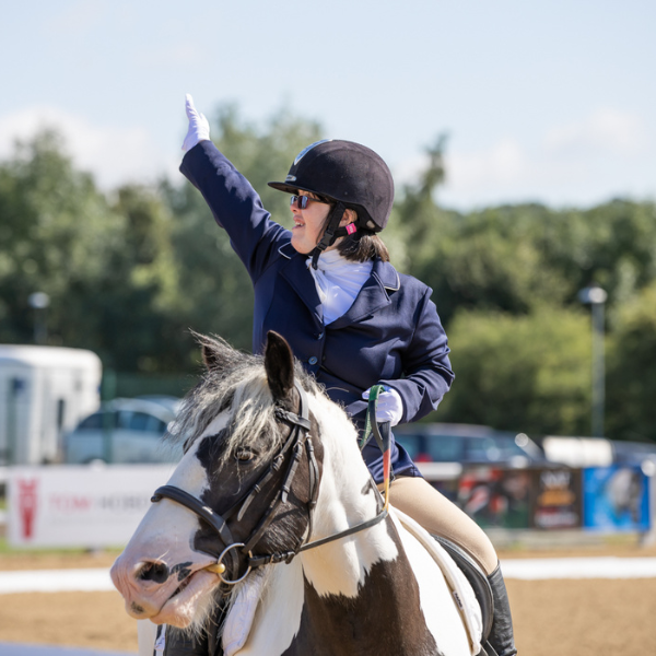 A dressage rider salutes to mark the end of their test.