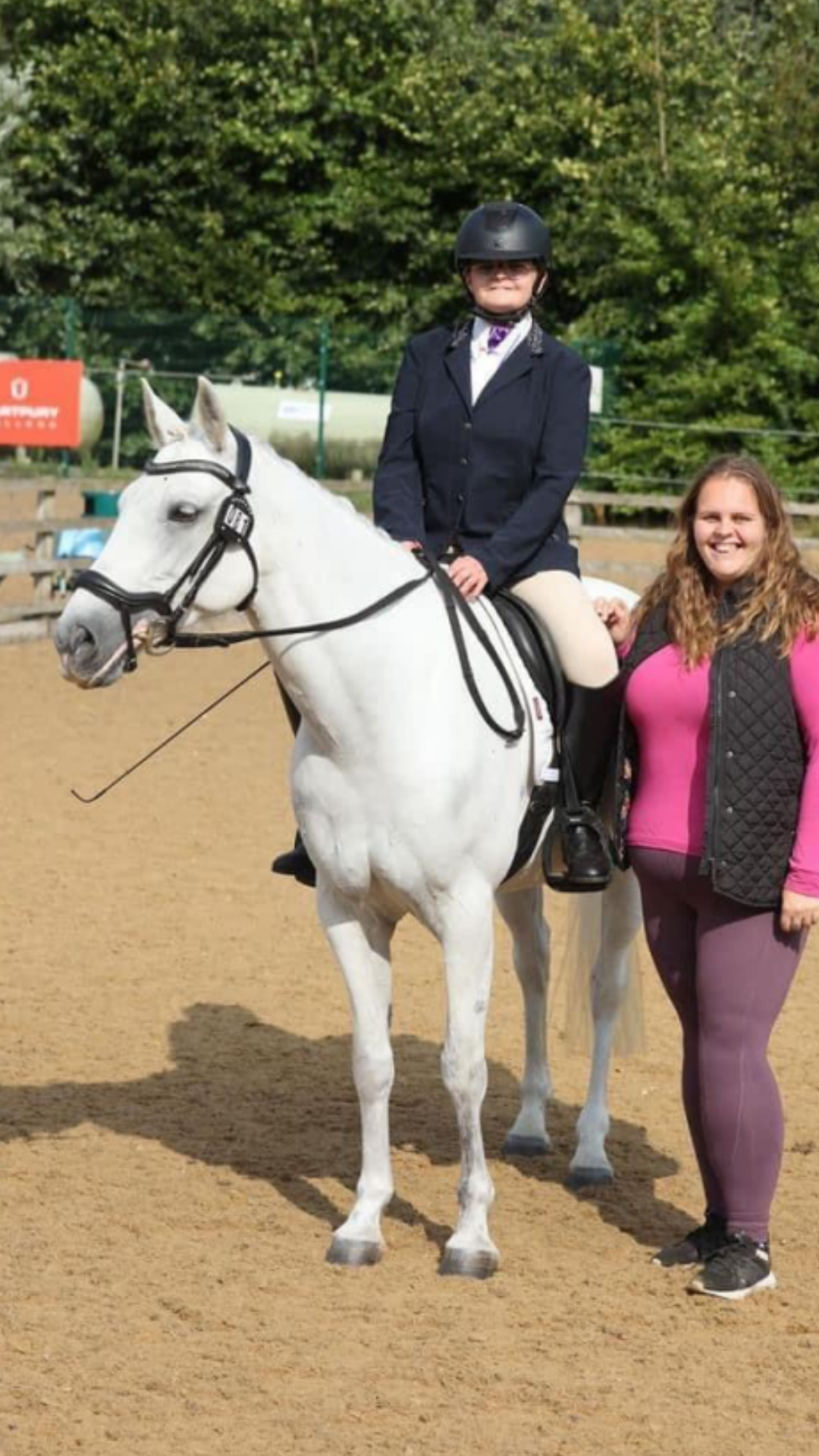 image of Mia in a dressage test on a grey horse with a volunteer