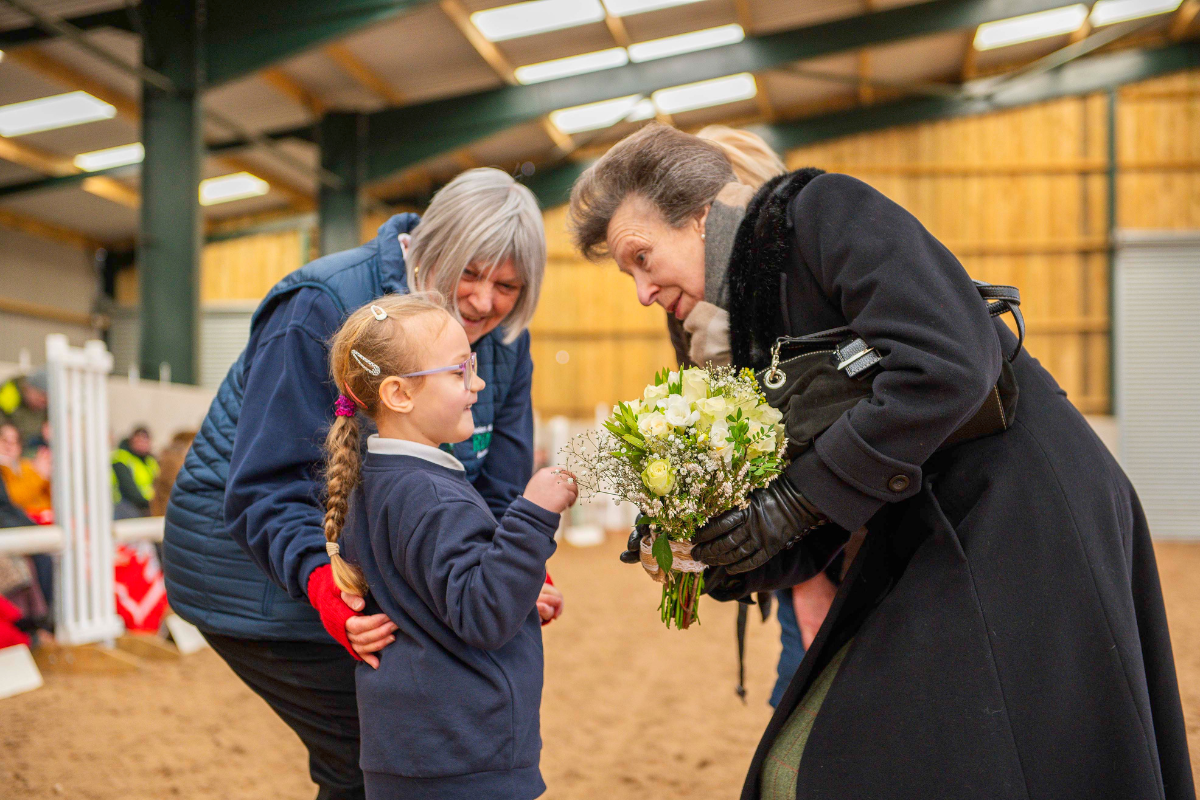 image of HRH receiving a posey of flowers from a RDA participant