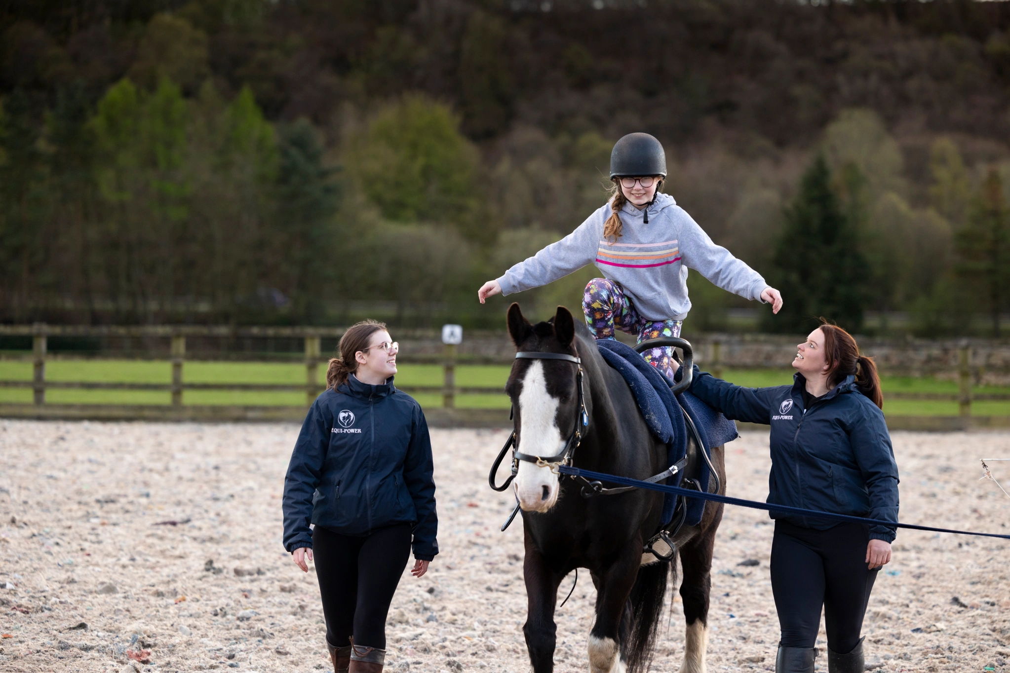 RDA participant practicing vaulting on a black horse with coaches