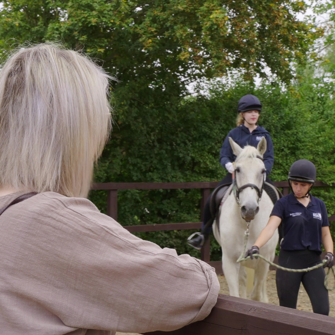 participant Miriam riding with her mum watching